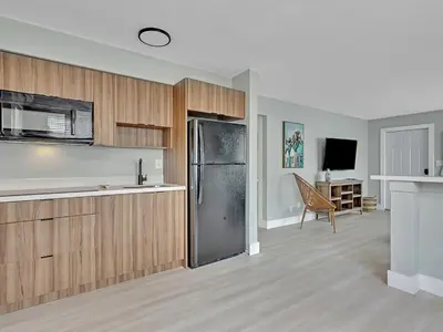 a kitchen with wooden cabinets and a refrigerator at Hollywood Beach 1BR Getaway | WiFi + AC in Dania Beach