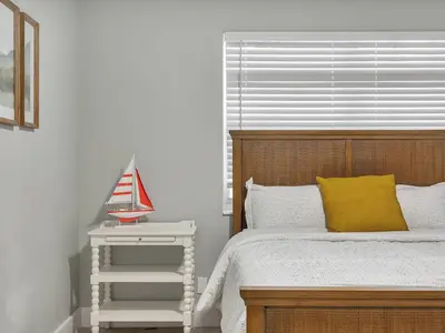 a bedroom with a bed with a yellow pillow and a side table at Hollywood Beach 1BR Getaway | WiFi + AC in Dania Beach