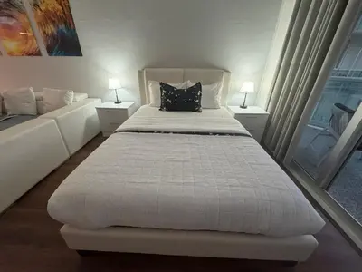 a bedroom with a large white bed with two lamps at Ocean Reserve Luxury Condo Sunny Isles Beach in Sunny Isles Beach