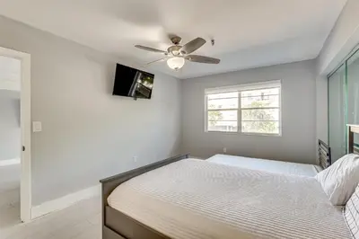 a bedroom with a bed and a ceiling fan at Sunny isles Escape-1BR Condo Steps from the Beach! in Sunny Isles Beach
