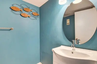 a bathroom with a mirror and a white sink at Sunny isles Escape-1BR Condo Steps from the Beach! in Sunny Isles Beach