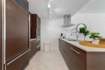 a kitchen with wooden cabinets and a sink at Luxury Miami Condo with Breathtaking City & Bay Views in Miami