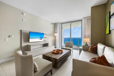 a living room with a couch and a tv at Beachfront Bliss W Ocean Views in Hollywood