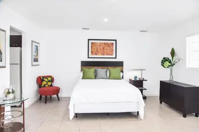 a bedroom with a white bed and a red chair at Buena Vista-Miami Designer Studio # 1 in Miami