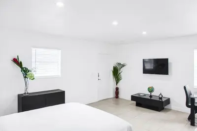 a white bedroom with a bed and a tv at Buena Vista-Miami Designer Studio # 1 in Miami