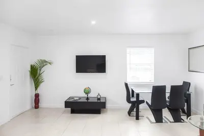 a white living room with a table and chairs at Buena Vista-Miami Designer Studio # 1 in Miami