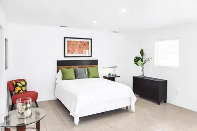 a bedroom with a white bed and a red chair at Buena Vista-Miami Designer Studio # 1 in Miami