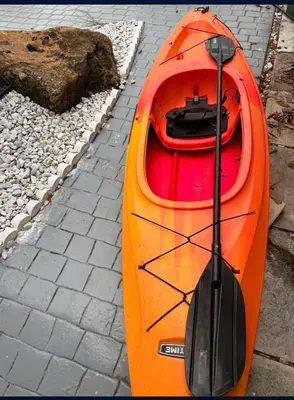an orange kayak with a paddle sitting on the ground at Hallandale Beach Club in Hallandale Beach