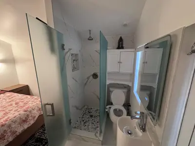 a small bathroom with a toilet and a sink at Hallandale Beach Club in Hallandale Beach