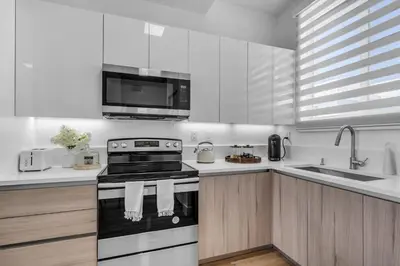 a white kitchen with a stove and a microwave at #207 brand new 2BR 2BA near brickell and stadium Central location in Miami