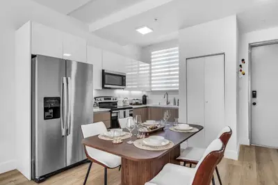 a kitchen with a table and chairs and a refrigerator at #207 brand new 2BR 2BA near brickell and stadium Central location in Miami