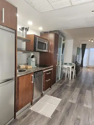 a kitchen with stainless steel appliances and wooden cabinets at Big studio with rooftop pool ocean view in Miami Beach