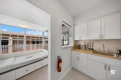 a kitchen with white cabinets and a large window at Spacious 1BD Beachside Apt with Free Parking in Miami Beach