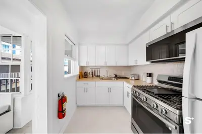a kitchen with white cabinets and a stove top oven at Spacious 1BD Beachside Apt with Free Parking in Miami Beach