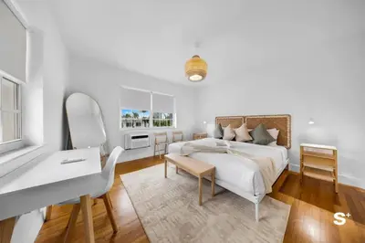 a white bedroom with a bed and a desk at Modern 1-BD Beachside Apt with Free Parking in Miami Beach
