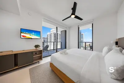 a white bedroom with a large bed and a flat screen tv at 2-BD Downtown Miami Condo with City Views in Miami