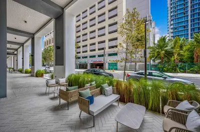 a patio with chairs and tables and a building at 2-BD Downtown Miami Condo with City Views in Miami