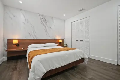 a bedroom with a large bed and a marble wall at Luxury 1 bedroom apt in Kendall Prime Location in Westwood Lake