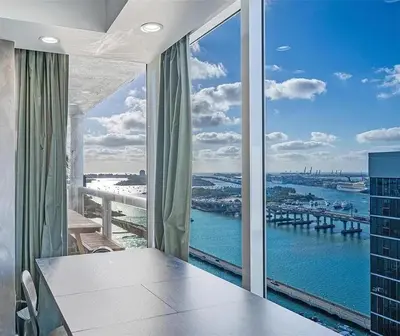 a dining room with a view of the water at Luxury 3-Bedroom Bayview Retreat at The Grand Miami in Miami