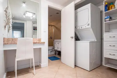 a kitchen with a white refrigerator and a white table at The Blue Octopus - 1br King Bed Condo in Fort Lauderdale