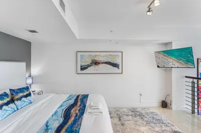 a bedroom with a bed and a painting on the wall at Brickell Miami LUXURY LOFT 2bd 2bth, Sleeps 6, Garage Parking, Walk to HOTTEST Restaurants & Nighlife in Miami