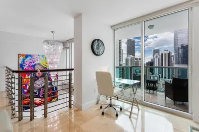 a living room with a table and a large window at Brickell Miami LUXURY LOFT 2bd 2bth, Sleeps 6, Garage Parking, Walk to HOTTEST Restaurants & Nighlife in Miami