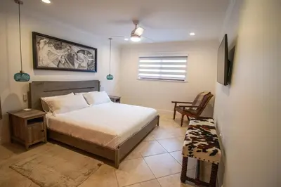 a bedroom with a bed and a chair and a window at Sunset in Sunset