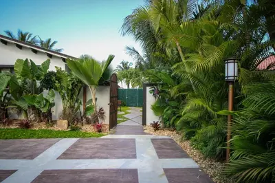 a walkway leading to a house with palm trees at Sunset in Sunset