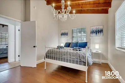 a bedroom with a white bed with blue pillows at 3 Home 12 bedroom compound with Pool and BBQ sleeps 24 in Miami