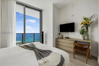 a bedroom with a bed and a desk with a television at Penthouse Vacation Beach Resort in Hollywood
