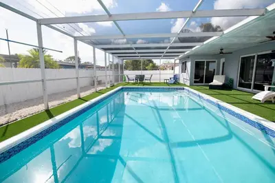 a swimming pool with a pergola next to a house at Luxury Retreat Near Hard Rock in Joe Robbie Stadium Heliport