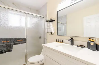 a bathroom with a shower and a sink and a mirror at Luxury Retreat Near Hard Rock in Joe Robbie Stadium Heliport