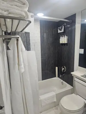 a bathroom with a white toilet and a bath tub at Ocean front paradise studio with ocean view and beach exit in Sunny Isles Beach