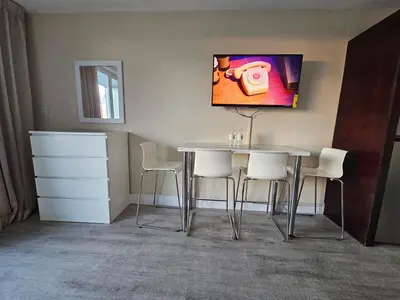 a table and chairs in a room with a painting on the wall at Beach Studio with City View in Sunny Isles Beach