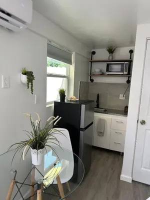 a kitchen with a glass table and a counter top at 2 Nice and Cozy guest house in Opa-locka