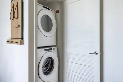 a laundry room with a washer and dryer next to a door at 3209 Apt in Heart of Downtown with Pool a Gym and Spa in Miami