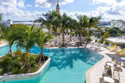 an aerial view of a resort pool with palm trees at 2414 Chic Stay in Miami Downtown with Bay and City Views a Pool and Gym in Miami