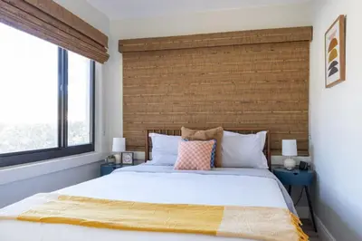 a bedroom with a large bed and two windows at Wynwood beautiful Art Deco home with 4 Bedroom in Miami