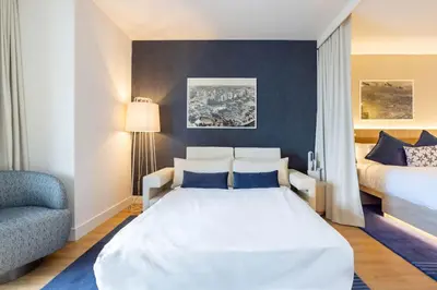 a bedroom with a large white bed and a chair at 2012 New Apt with Pool and Gym in front of Kaseya Center in Miami
