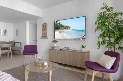 a living room with purple chairs and a tv on a wall at 3001 Miami Downtown Apt with Gym and Pool next to Kaseya Center in Miami