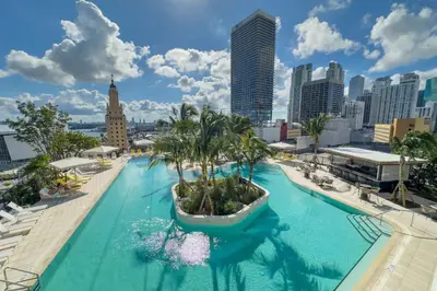 a pool with palm trees on the roof of a building at 3001 Miami Downtown Apt with Gym and Pool next to Kaseya Center in Miami