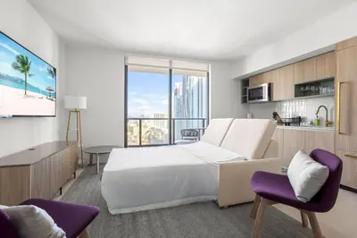 a bedroom with a large white bed and purple chairs at 2901 Beautiful Downtown Apt with Pool and Gym in Miami