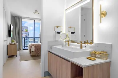 a bathroom with a sink and a large mirror at 2704 Beautiful Downtown Apt with Gym Pool Spa Skyline Views and in front of Kaseya Center in Miami