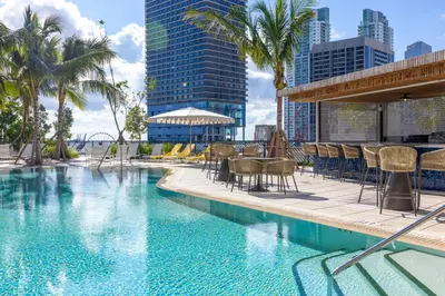 a swimming pool with chairs and tables and buildings at 3808 Apt Next to Kaseya Center with Pool a Spa and Gym in Miami