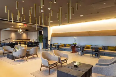 a lobby with chairs and tables and a chandelier at 3312 Modern Apt in front of Kaseya Center with Pool and Gym in Miami