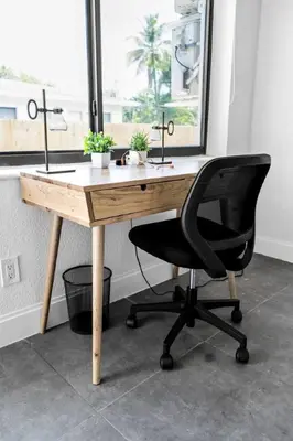 a wooden desk with a black chair in front of a window at Unit 2 Cute Studio in North Miami 10min to beach in Miami