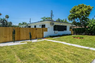a white house with a wooden fence at Unit 2 Cute Studio in North Miami 10min to beach in Miami