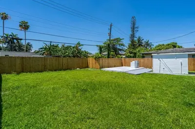 a backyard with a fence and green grass at Unit 2 Cute Studio in North Miami 10min to beach in Miami