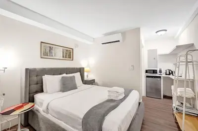 a bedroom with a large bed and a kitchen at Eden Collection Junior Suite Steps to Beach in Fort Lauderdale