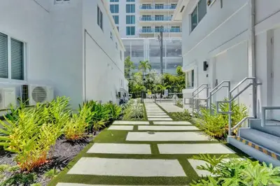a walkway outside of a building with plants at Eden Collection Junior Suite Steps to Beach in Fort Lauderdale